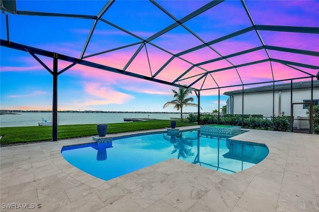 pool at dusk featuring an in ground hot tub, a lanai, a water view, a patio area, and a lawn