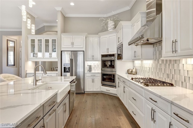 kitchen with white cabinetry, wall chimney range hood, stainless steel appliances, and tasteful backsplash