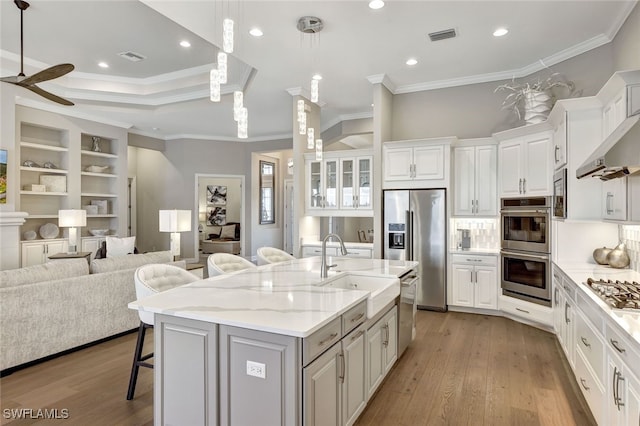 kitchen featuring white cabinets, a spacious island, a breakfast bar area, and sink