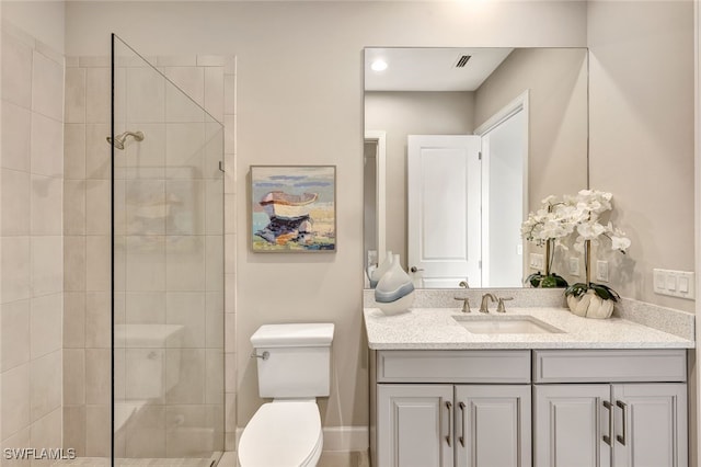 bathroom featuring tiled shower, vanity, and toilet