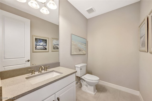 bathroom featuring tile patterned flooring, vanity, toilet, and a notable chandelier