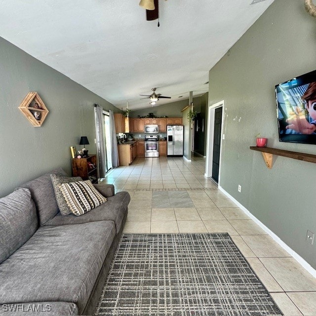 tiled living room featuring ceiling fan and vaulted ceiling