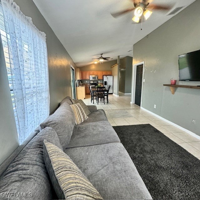 tiled living room with ceiling fan and vaulted ceiling