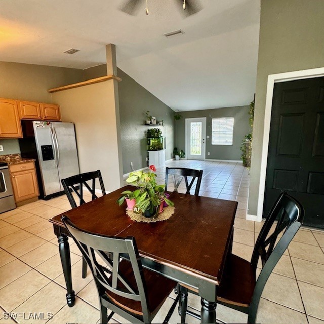 dining area with vaulted ceiling, ceiling fan, and light tile patterned floors