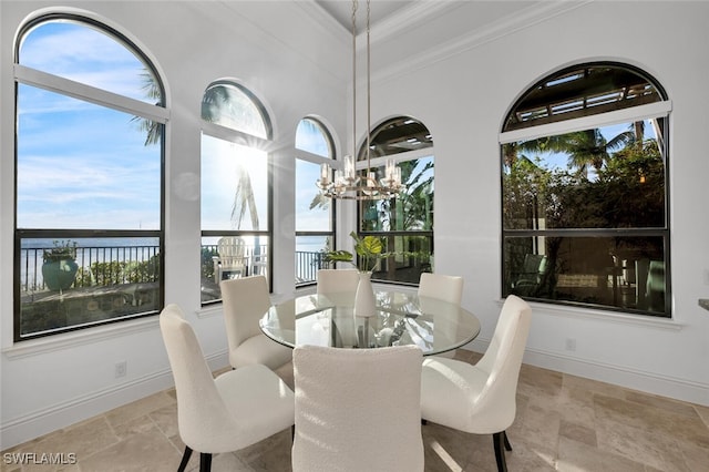 dining room featuring a chandelier, crown molding, and a water view