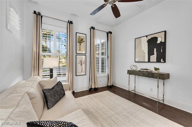 living room featuring ceiling fan and dark wood-type flooring