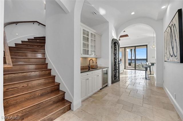 bar featuring sink, white cabinetry, beverage cooler, and tasteful backsplash