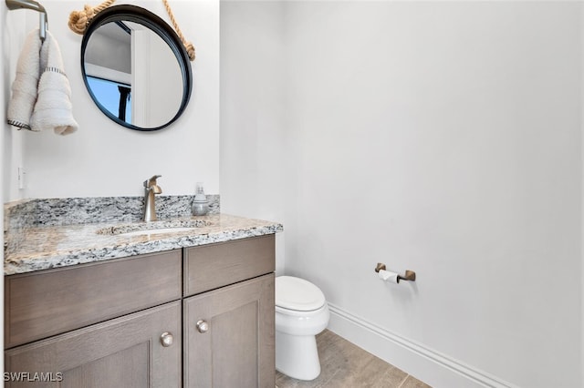 bathroom featuring wood-type flooring, toilet, and vanity