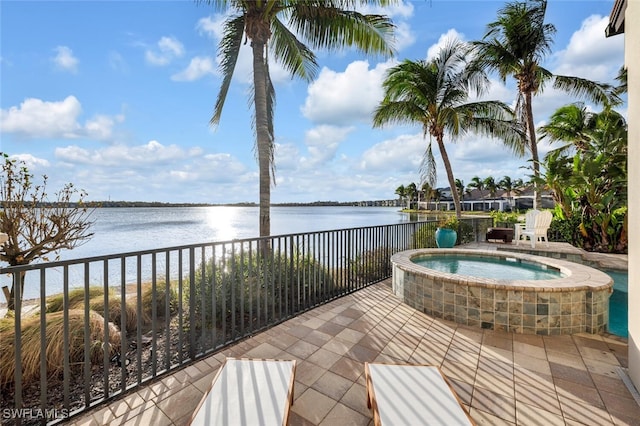 view of patio / terrace with an in ground hot tub and a water view