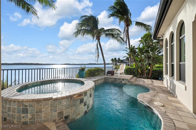 view of swimming pool featuring an in ground hot tub and a water view