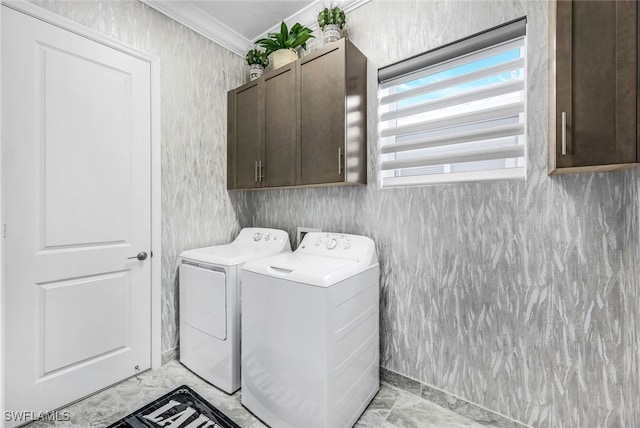 laundry room featuring cabinets, ornamental molding, and washer and clothes dryer