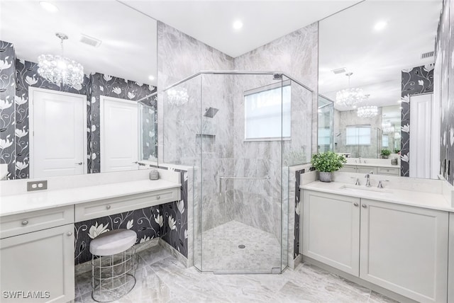 bathroom with vanity, a shower with door, and a chandelier