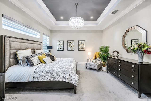 carpeted bedroom featuring a notable chandelier, a tray ceiling, and ornamental molding