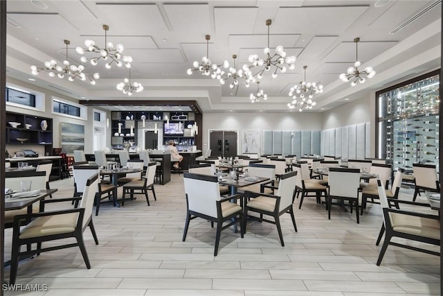 dining space featuring a raised ceiling and a notable chandelier