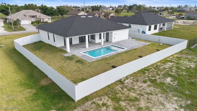 rear view of property with a patio, a fenced in pool, and a yard