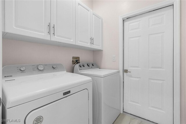 laundry area featuring cabinets and washer and clothes dryer