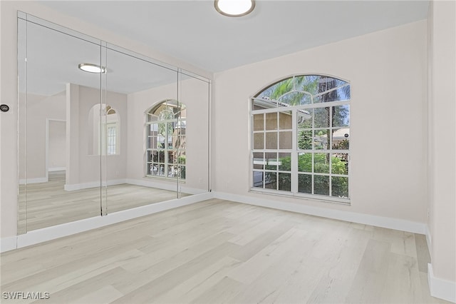 empty room with hardwood / wood-style flooring and plenty of natural light