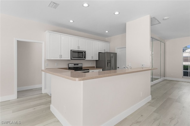 kitchen featuring white cabinetry, stainless steel appliances, kitchen peninsula, and light wood-type flooring