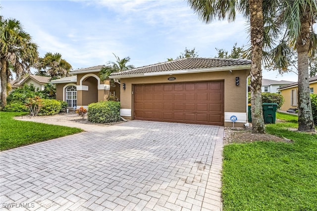 mediterranean / spanish-style home featuring a garage and a front lawn