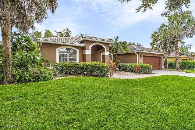 mediterranean / spanish-style home featuring a garage and a front yard