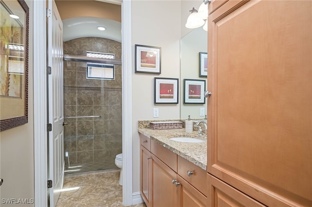 bathroom with toilet, walk in shower, vanity, and tile patterned flooring