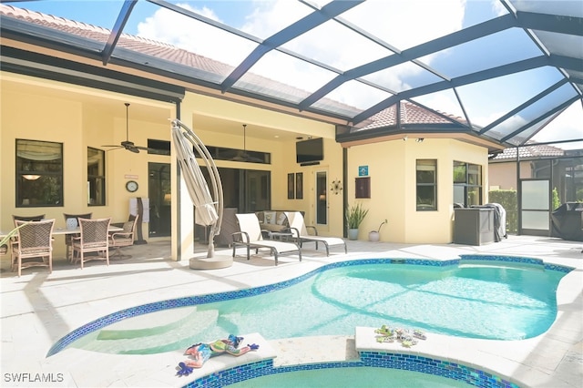 view of swimming pool with ceiling fan, a lanai, a patio area, and an outdoor living space