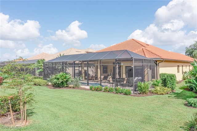 rear view of property with a lanai and a yard