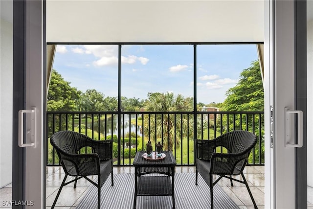 sunroom featuring a wealth of natural light and a water view