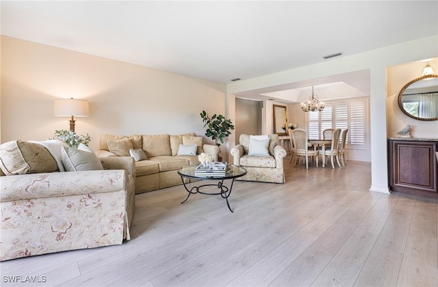 living room featuring a notable chandelier and light hardwood / wood-style floors