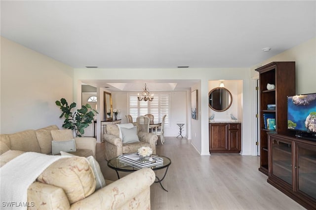 living room with a chandelier and light wood-type flooring