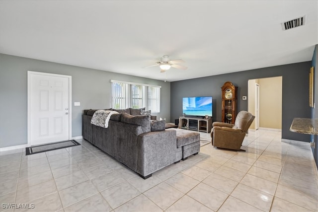 living room featuring ceiling fan, light tile patterned flooring, visible vents, and baseboards