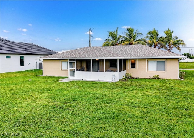 rear view of property with a lawn and a sunroom