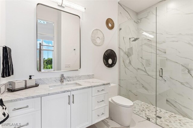 bathroom featuring an enclosed shower, vanity, and toilet