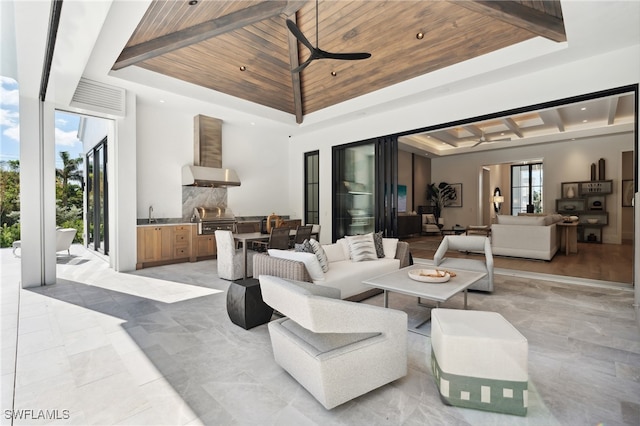 living room featuring beamed ceiling, sink, a raised ceiling, and wood ceiling