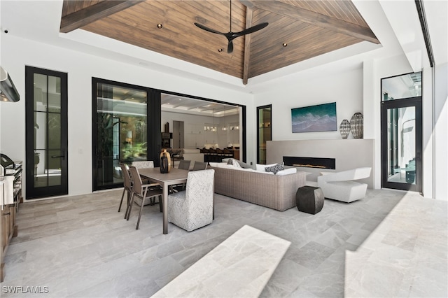 living room with ceiling fan, a towering ceiling, and wood ceiling