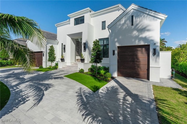 contemporary home featuring a garage, driveway, and stucco siding