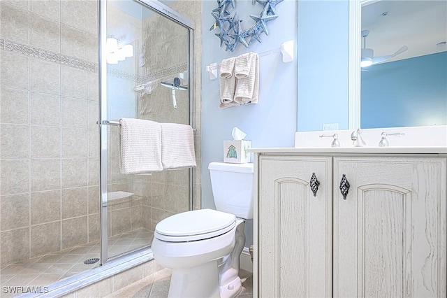 bathroom featuring toilet, tile patterned flooring, a shower with door, and vanity