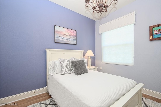 bedroom with light wood-type flooring and a chandelier