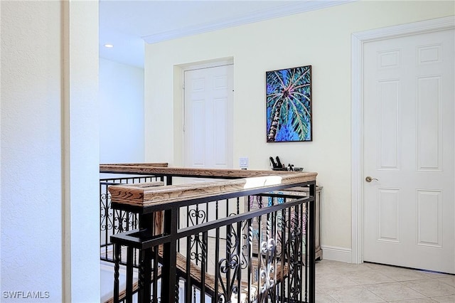 hall featuring light tile patterned floors and ornamental molding