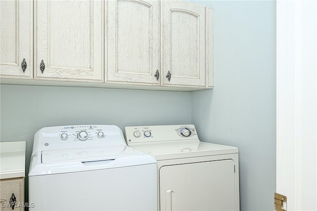 laundry room with washer and dryer and cabinets