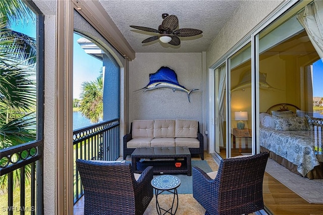 balcony featuring ceiling fan and a water view