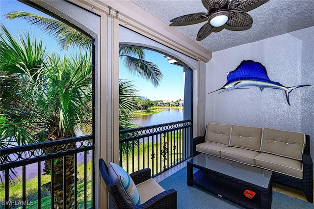 balcony with ceiling fan and a water view