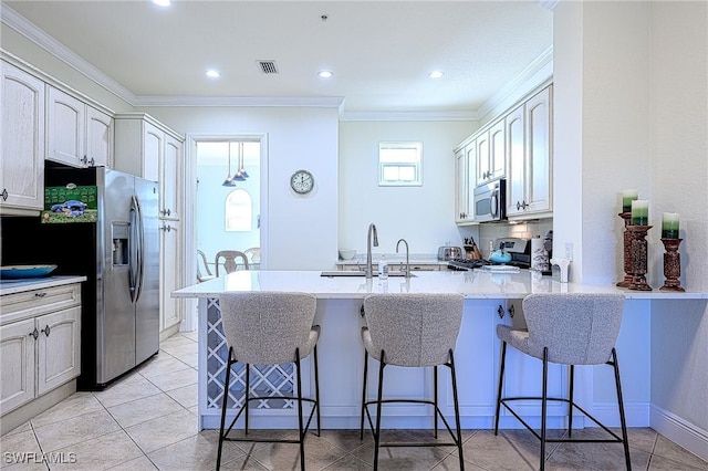 kitchen featuring appliances with stainless steel finishes, ornamental molding, kitchen peninsula, and a breakfast bar area