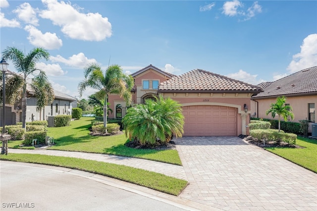 mediterranean / spanish home with central AC, a front lawn, and a garage