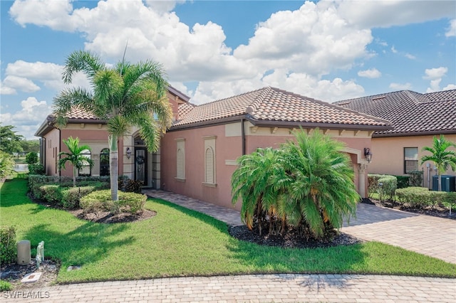 mediterranean / spanish-style house with a garage and a front lawn