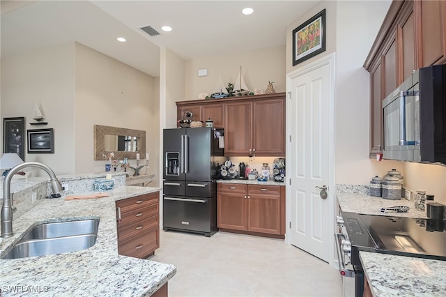 kitchen with light stone countertops, sink, and black appliances