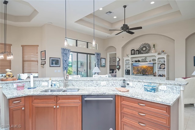 kitchen featuring hanging light fixtures, stainless steel dishwasher, a tray ceiling, and ceiling fan