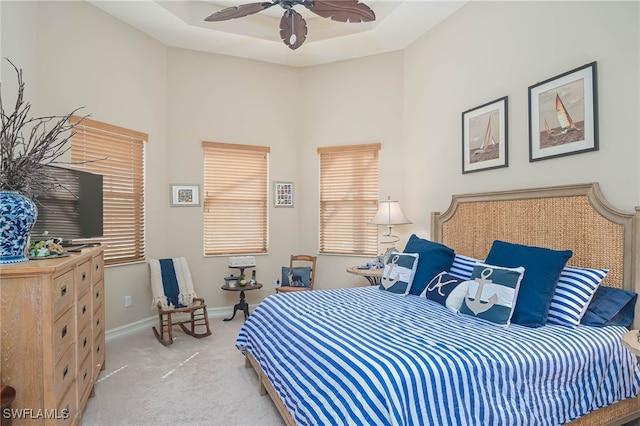 carpeted bedroom featuring multiple windows and ceiling fan