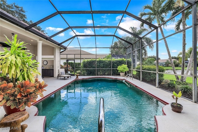 view of pool with glass enclosure and a patio