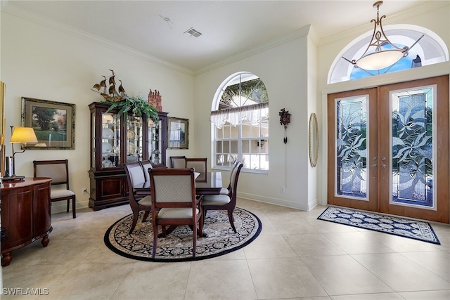 dining area featuring french doors, crown molding, light tile patterned floors, and a high ceiling